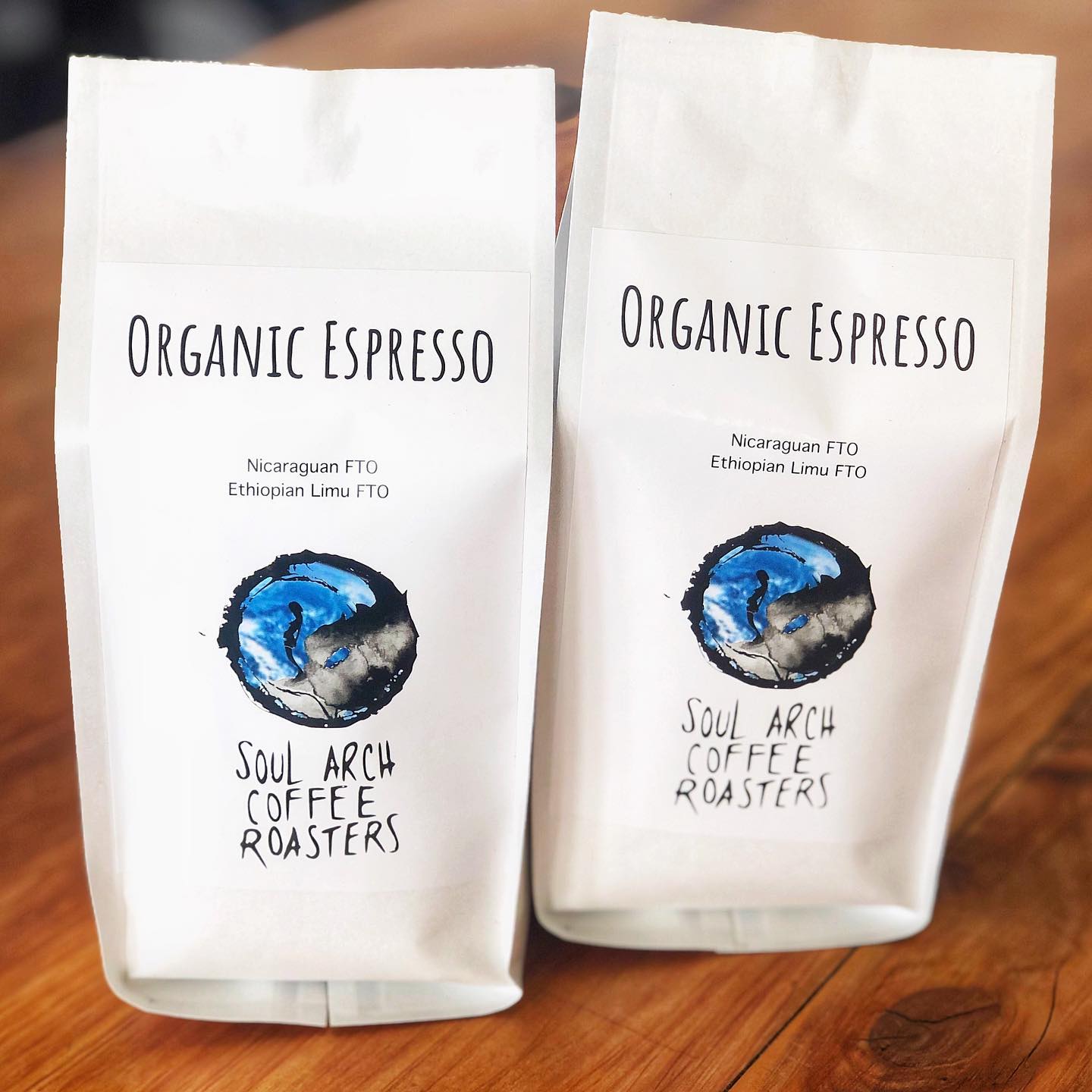 Two Organic Espresso bags with a blue ink logo
